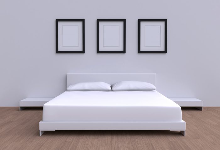 Modern bed with two pillows, tables and three picture frame from